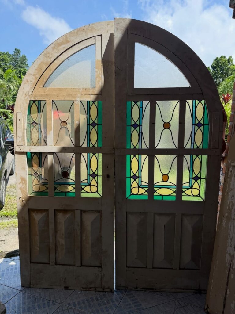 Porta antiga de madeira com vitrais coloridos.