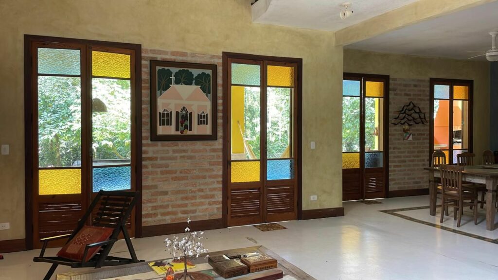 Porta balcão de pinho de riga com vidros coloridos e estrutura de madeira antiga, peça de demolição ideal para projetos de arquitetura com materiais históricos e decoração rústica.