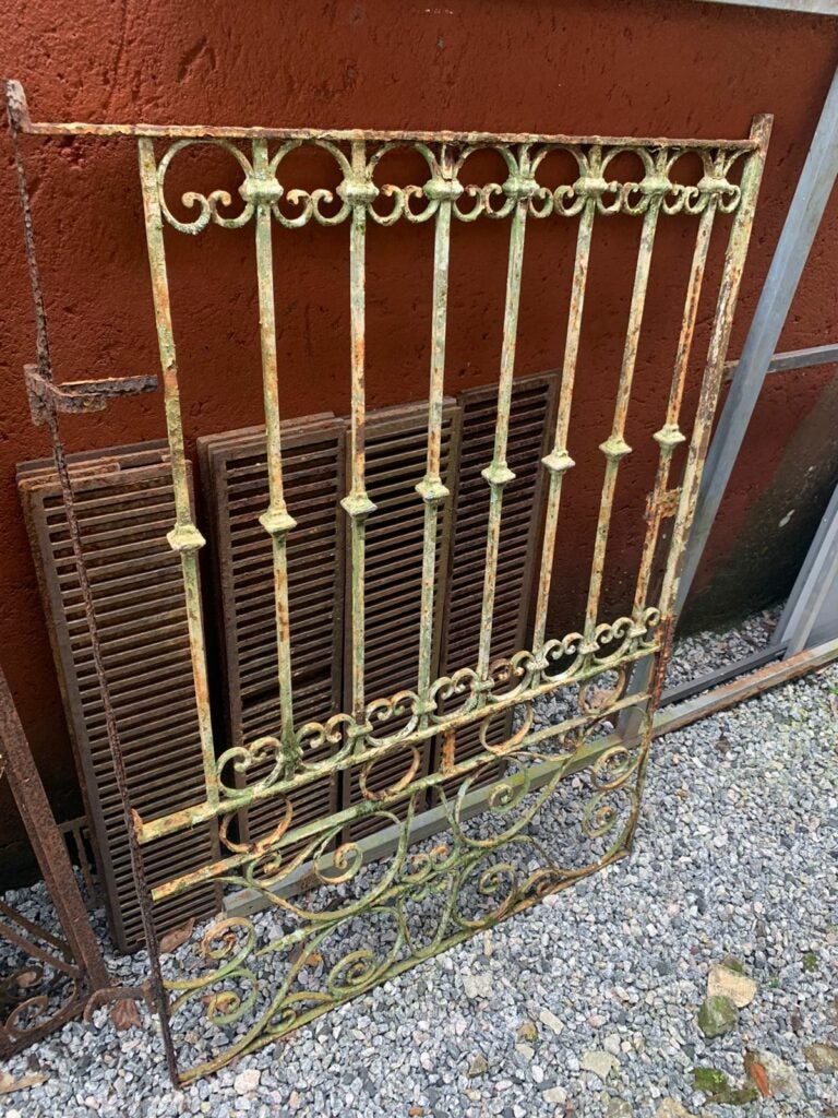 Grade antiga de ferro com ornamentos e pintura desgastada