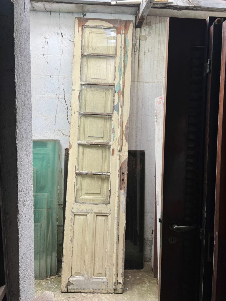 Porta antiga de madeira com pintura desgastada e diferentes camadas de tinta